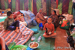 避難用の仮設テントで生活する家族