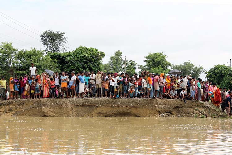 道路が水に浸かり、救助用ボートを待つ人々（ネパール） / ©プラン・インターナショナル