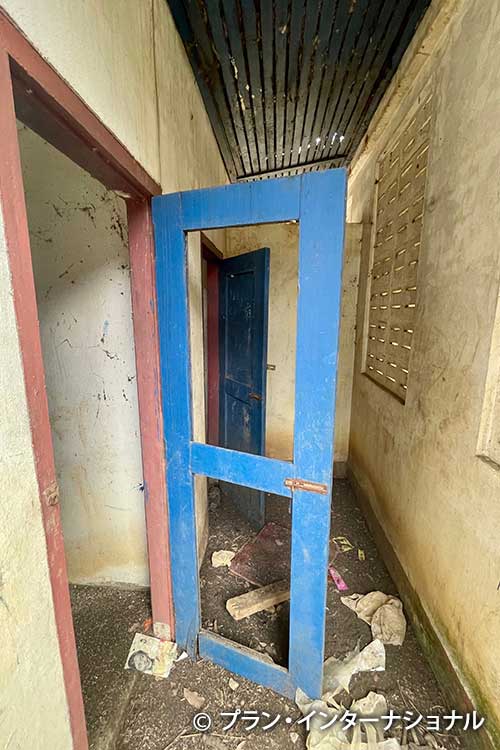 写真：扉が壊れて使用できない状態の学校トイレ