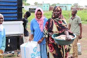 支援物資を受け取る女性（スーダン） / ©プラン・インターナショナル