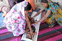 世帯訪問で幼児の身長測定をする栄養指導員(左) / ©プラン・インターナショナル