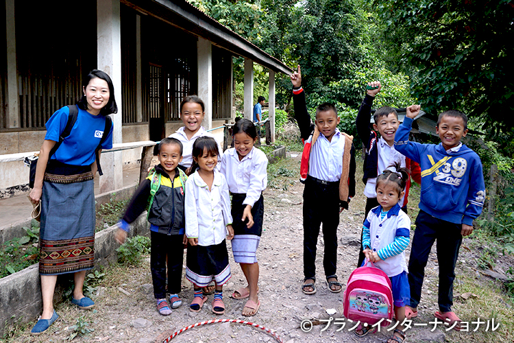 写真：対象地域の子どもたちと鈴村職員（左）