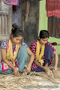 籐で敷物を織るバクルさん（左）と妹（右）