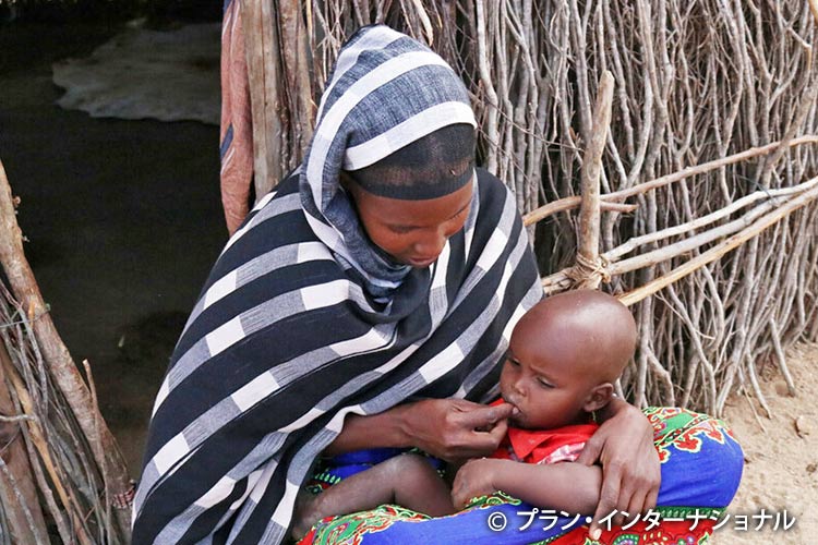 写真：栄養不良の子どもにおかゆを食べさせる母親（ケニア）