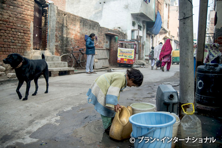 写真：スラム街で水汲みをする女の子（インド）
