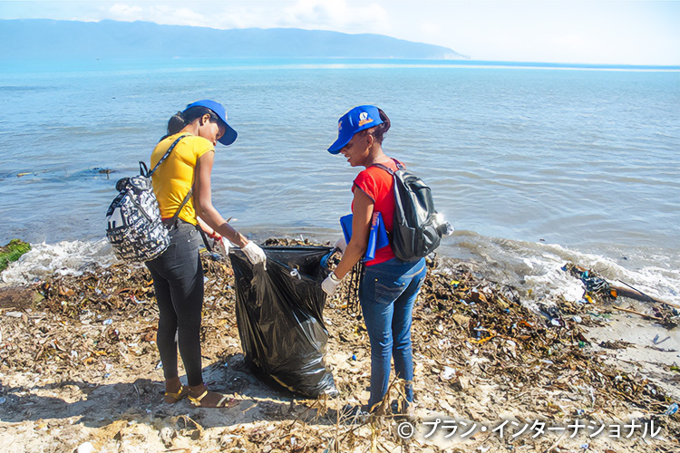 写真：海岸のごみ拾いをする若者たち（ドミニカ）