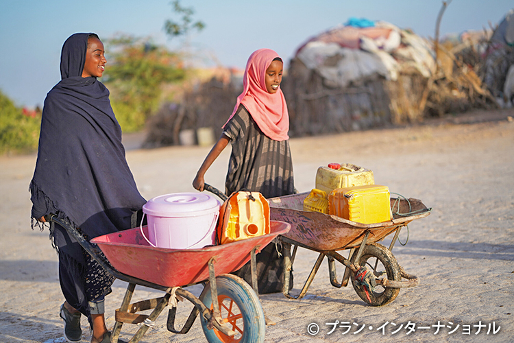 写真：家まで水を運ぶ女の子たち（ソマリア）