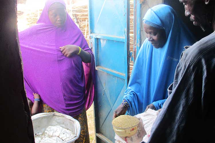 穀物銀行で穀物を受け取る住民の女性 / ©プラン・インターナショナル
