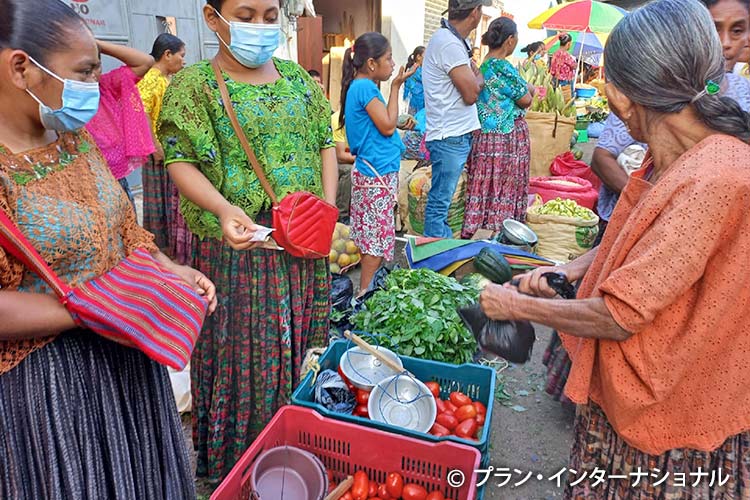 写真:近くの町で採れたトマトを売る女の子たち