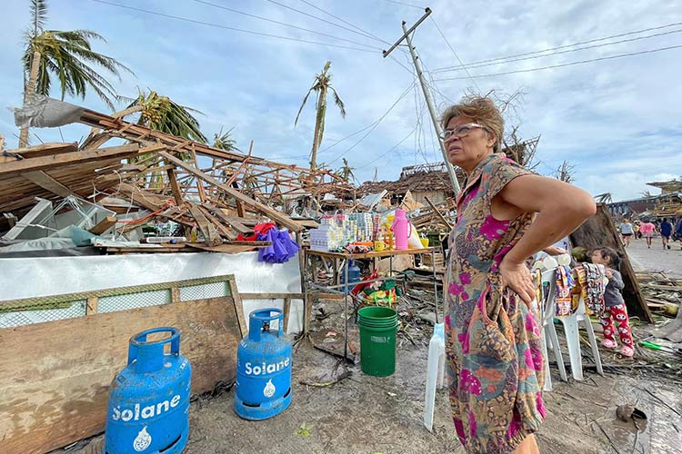 写真：被災した自宅の前に立ちつくす女性