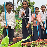 写真：学校菜園での活動を楽しむマオさん（左から2番目）