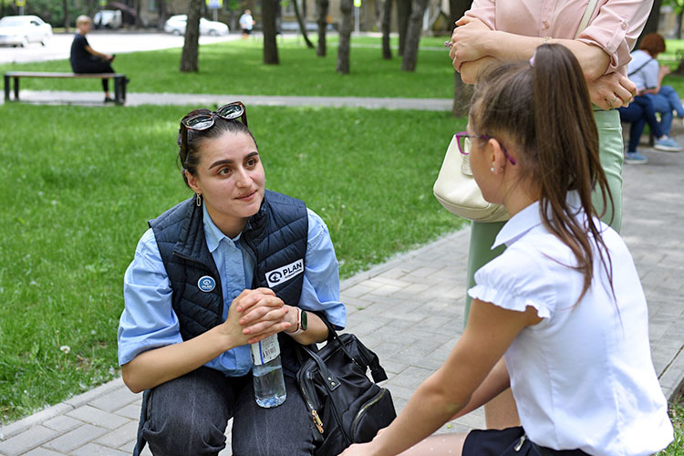 女の子に新しい生活の様子を尋ねるプラン職員（モルドバ） / ©プラン・インターナショナル