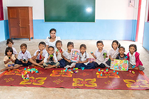 支給された敷物に座り玩具を手にする子どもたち / ©プラン・インターナショナル