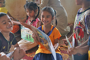 就学準備コースに参加し絵本を読む女の子 / ©プラン・インターナショナル