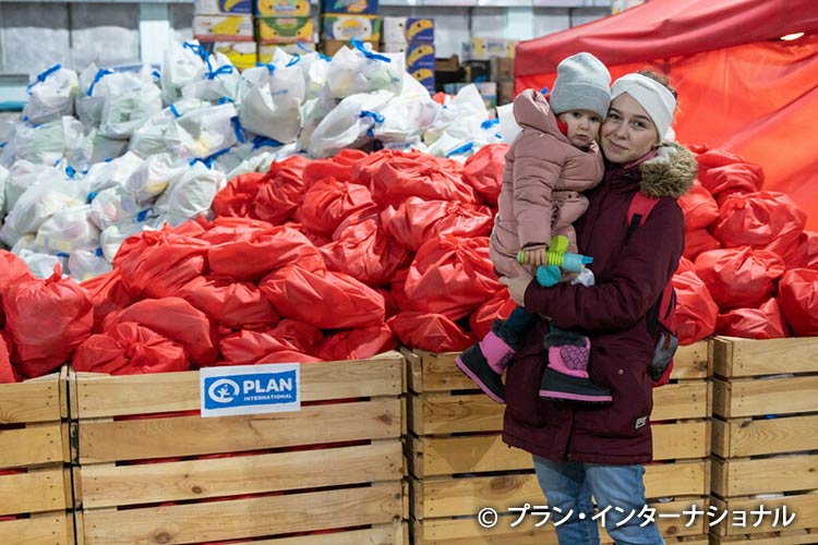 写真：食料や衣料を受け取りにきた母子（モルドバ）
