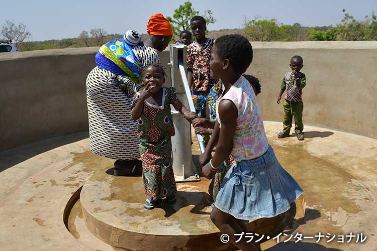 写真：嬉しそうに井戸の水をくむ子どもたち