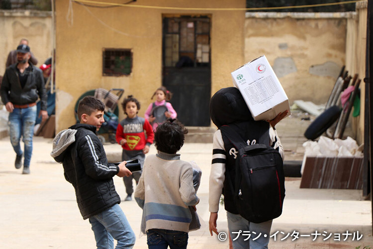 写真：支援物資を運ぶ子どもたち