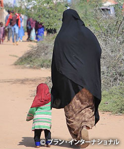 写真：避難民キャンプを歩くヒボさんと娘