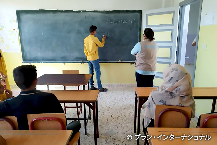 写真:補習授業を受けるハサンさん(11歳)