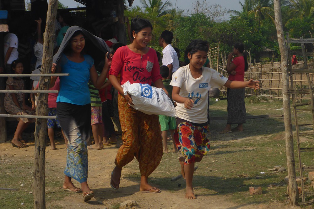 子どもキットを受け取り、喜ぶ親子（ミャンマー） / ©プラン・インターナショナル