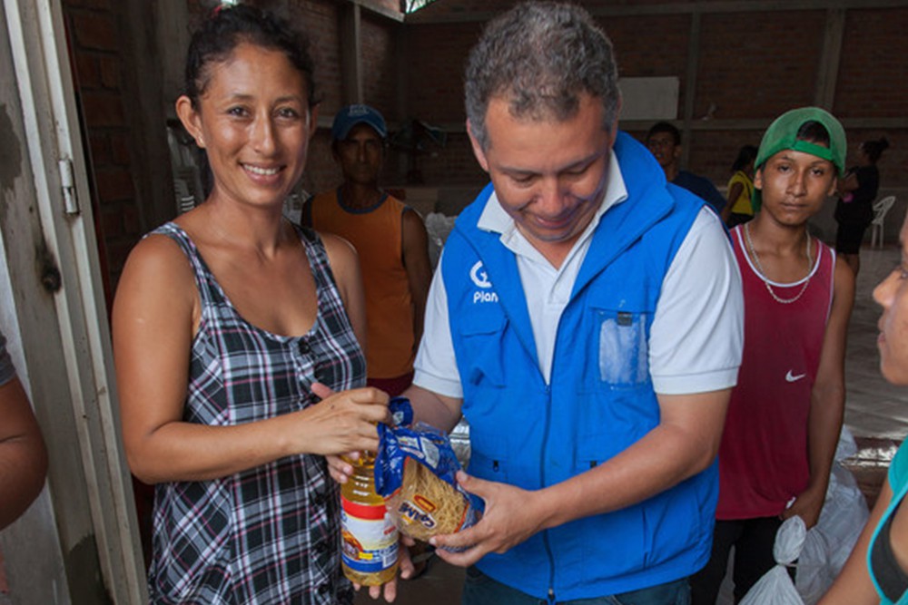 食料品を受け取る被災者 / ©プラン・インターナショナル