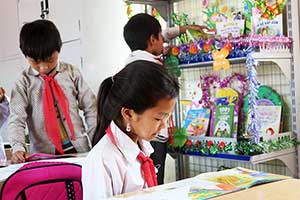 導入された図書コーナーで読書を楽しむ児童 / ©プラン・インターナショナル