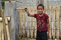 完成した共同水栓と男の子 / ©プラン・インターナショナル