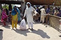 シェルターキットを受け取り、笑顔を見せる住民（パキスタン） / ©プラン・インターナショナル