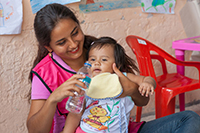 「子どもひろば」で幼児の世話をするボランティア / ©プラン・インターナショナル