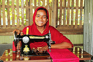 縫製の指導を受けた後、受注した服を仕立てる女性 / ©プラン・インターナショナル