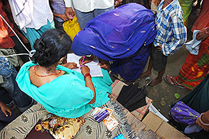 衛生用品、消毒剤を受け取る女性（インド） / ©プラン・インターナショナル