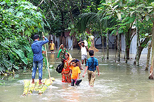 広範囲にわたる洪水で家が被災し、避難する人々（バングラデシュ） / ©プラン・インターナショナル
