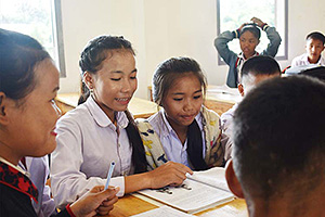 クラスメートと本を読む子どもクラブリーダーの女の子 / ©プラン・インターナショナル