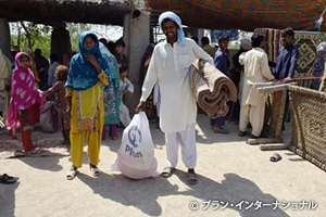 物資を受け取り、笑顔を見せる住民（パキスタン）
