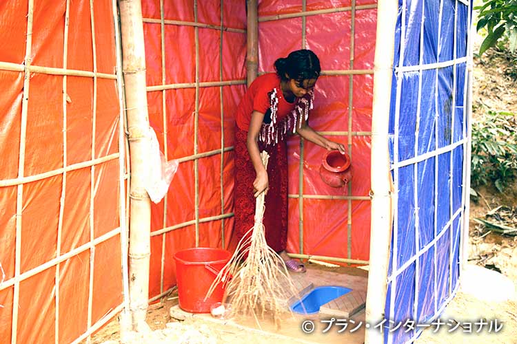 写真：プランの支援で建てられた公共トイレを掃除する女性