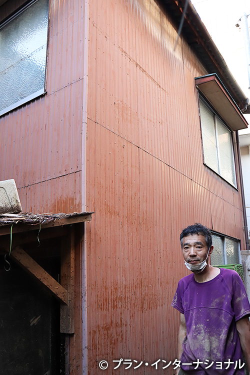写真：2階の窓枠まで浸水した跡を見せてくださる岡澤さん