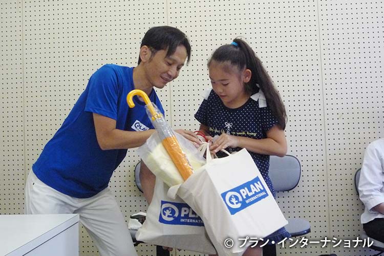 写真:野村小学校で学用品を受け取る女の子