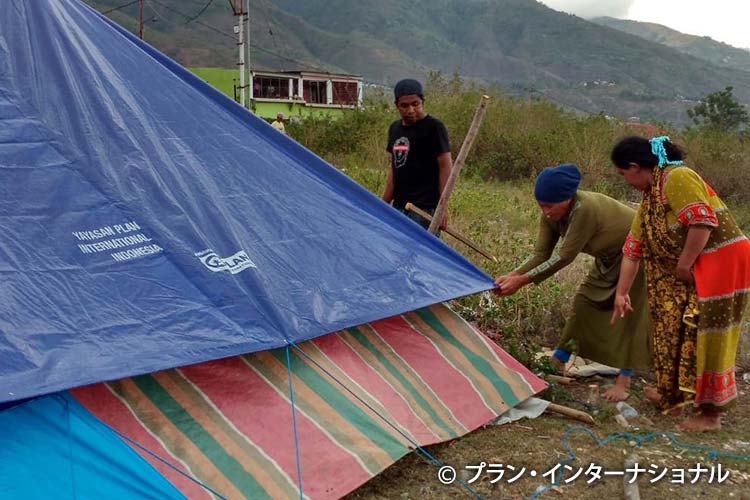 写真：提供したシェルターキットのテントを組み立てる人々