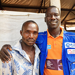 写真：アンソニーさん、34歳、ウガンダに居住する難民（写真左）