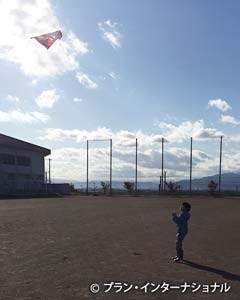 写真：広いグラウンドで凧揚げを楽しむ