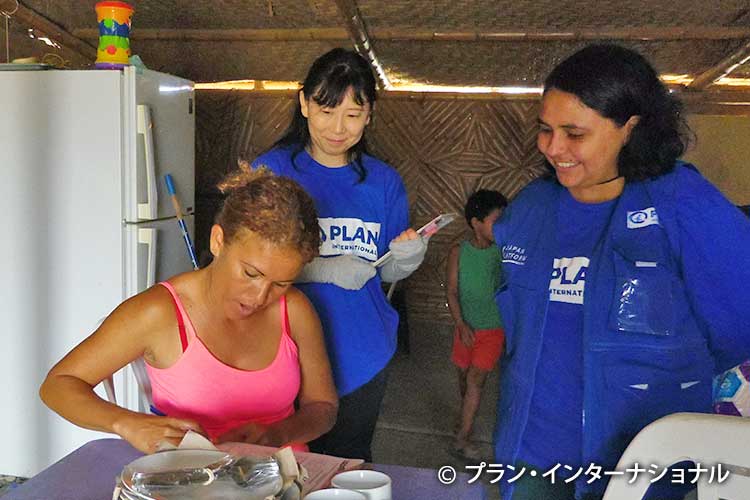写真：新しい調理用器具を受け取り喜ぶ避難民の女性