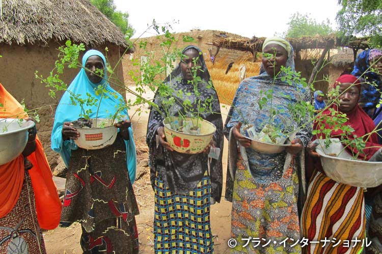 写真：支給された苗を持つ女性たち