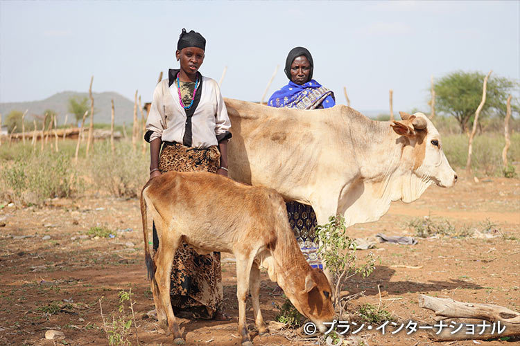 写真：やせ衰えた家畜を見守る母と娘（エチオピア）
