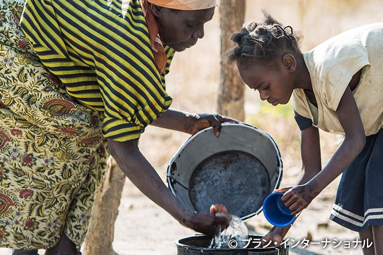 写真:母親と家事にいそしむチボンボ郡の女の子