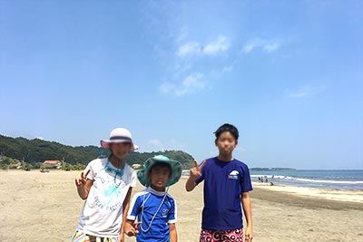 写真:海辺でポーズをとる支援者の家族の写真