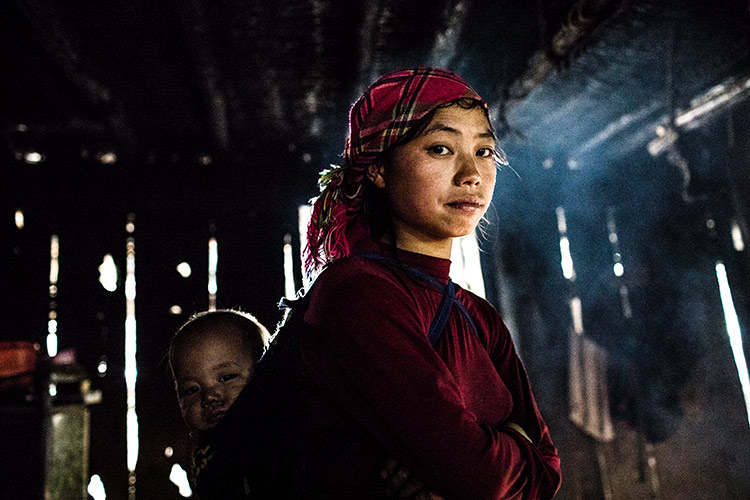 写真：家事をしながら子育てをする女の子（ベトナム）