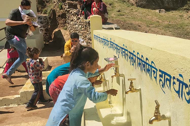 写真：完成した給水設備を利用する子どもたち