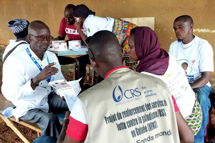 写真：配布された抗マラリア薬の説明を受ける女性（ギニア）