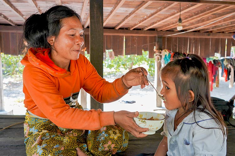 写真:栄養改善トレーニングを受け健康的な食事を与える母親（カンボジア）