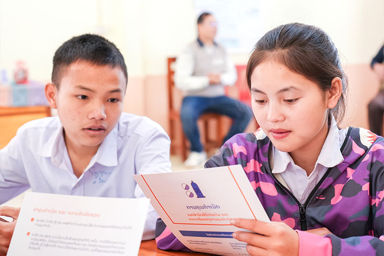 写真：配布した補助教材で衛生について学ぶ生徒クラブ